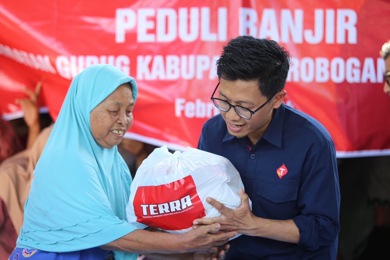 Manager Network Operations and Productivity Hermann Hermitch menyerahkan bantuan csr berupa sembako kepada salah satu warga terdampak banjir di Grobogan.